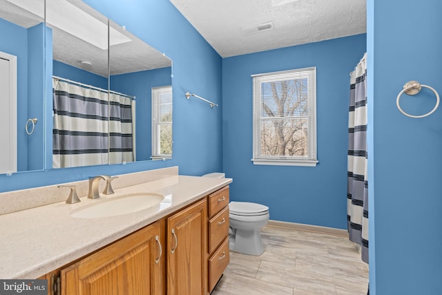 bathroom with vanity, curtained shower, a textured ceiling, and toilet