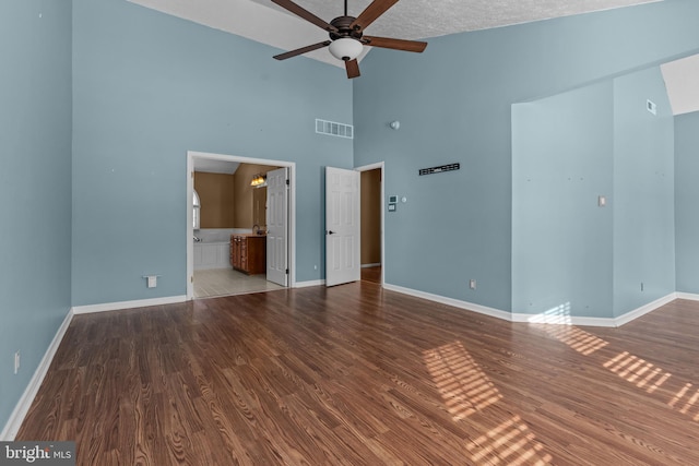 unfurnished room with ceiling fan, wood-type flooring, high vaulted ceiling, and a textured ceiling