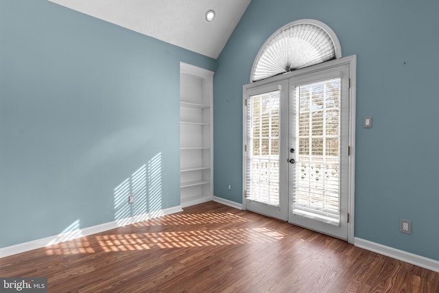 spare room with french doors, lofted ceiling, built in features, and hardwood / wood-style flooring