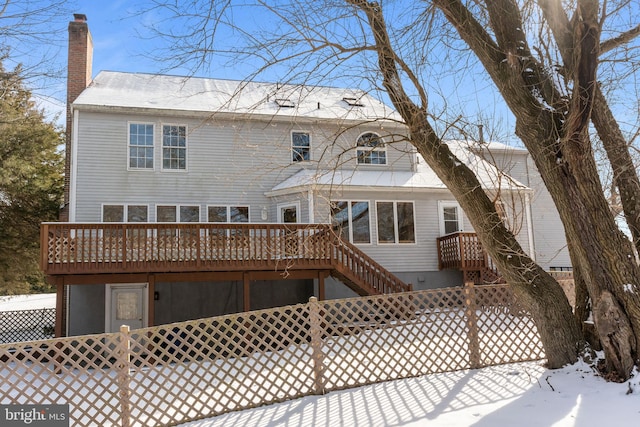 snow covered house featuring a wooden deck