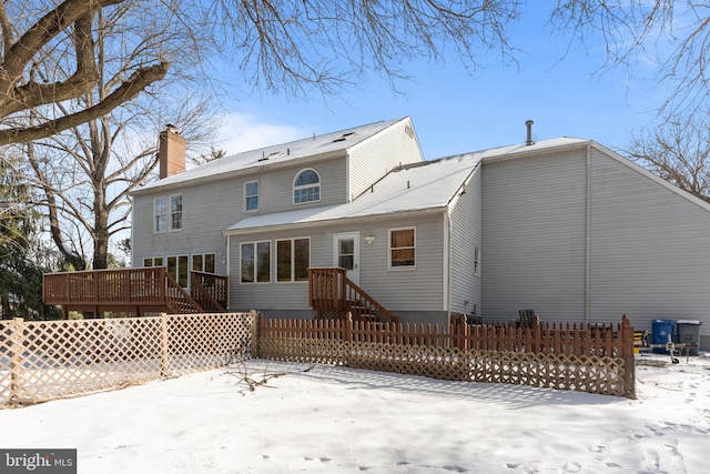 snow covered rear of property featuring a wooden deck