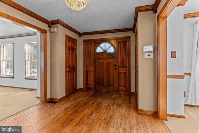 foyer entrance featuring ornamental molding and wood-type flooring