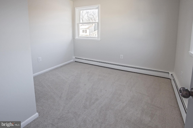 spare room with a baseboard radiator and light colored carpet