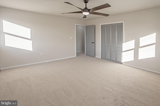 unfurnished bedroom featuring ceiling fan, light colored carpet, and a closet