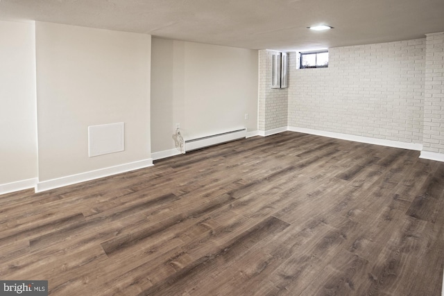 basement with a baseboard radiator, brick wall, and dark wood-type flooring