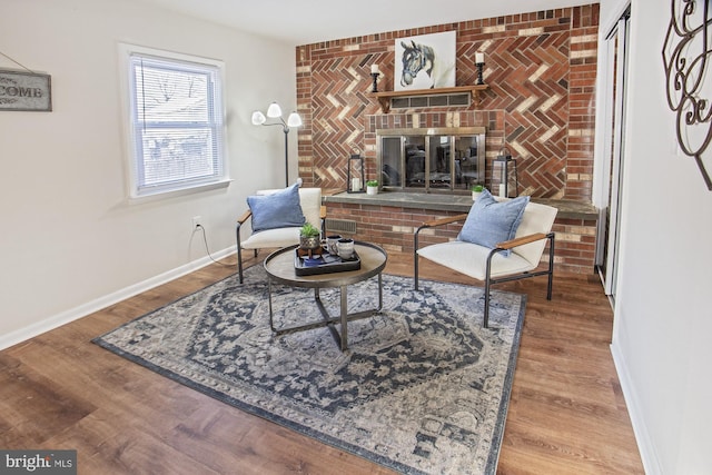 living area with hardwood / wood-style flooring and a fireplace