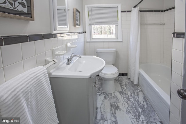 full bathroom with vanity, toilet, tile walls, and shower / bath combo