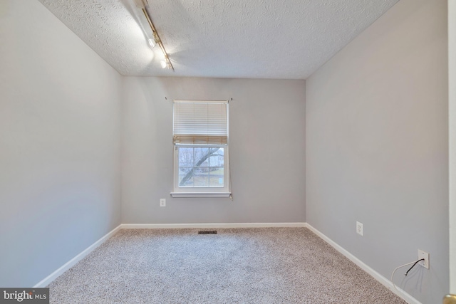 unfurnished room with carpet floors and a textured ceiling