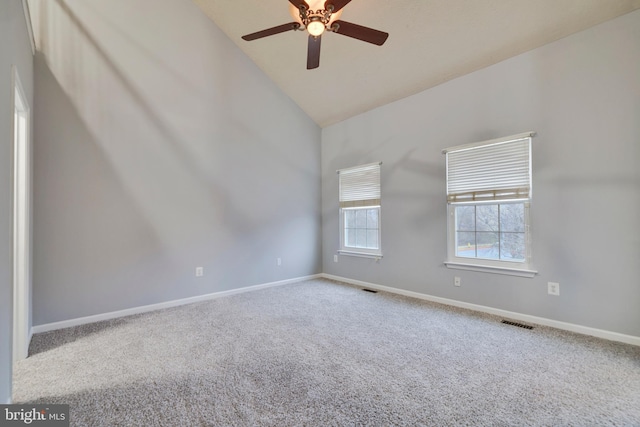 empty room featuring high vaulted ceiling, ceiling fan, and carpet flooring