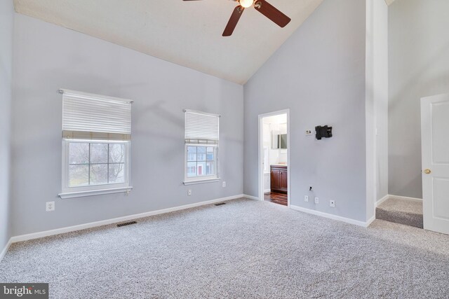 unfurnished bedroom featuring ceiling fan, connected bathroom, carpet flooring, and high vaulted ceiling