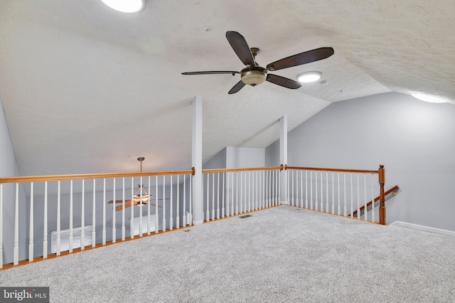 additional living space with ceiling fan, lofted ceiling, carpet flooring, and a textured ceiling