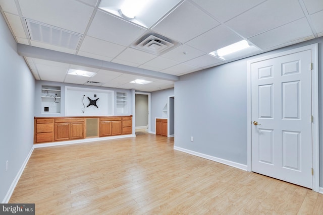 interior space featuring a paneled ceiling and light wood-type flooring