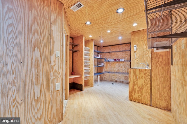 interior space featuring wood-type flooring, wooden ceiling, and wooden walls