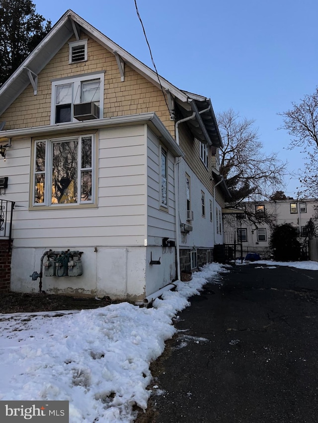 view of snow covered exterior featuring cooling unit