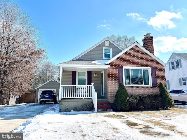 bungalow-style house featuring a garage, an outdoor structure, and covered porch