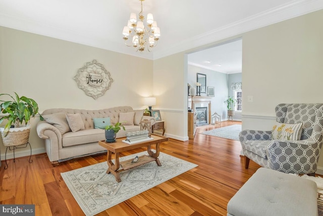 living room featuring ornamental molding, light hardwood / wood-style floors, and a notable chandelier