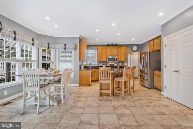 kitchen featuring ornamental molding, stainless steel appliances, a kitchen bar, and a kitchen island