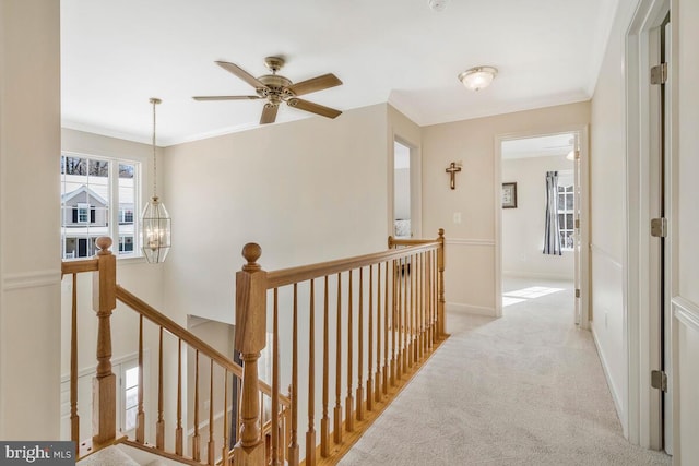 hall featuring ornamental molding, light colored carpet, and a notable chandelier