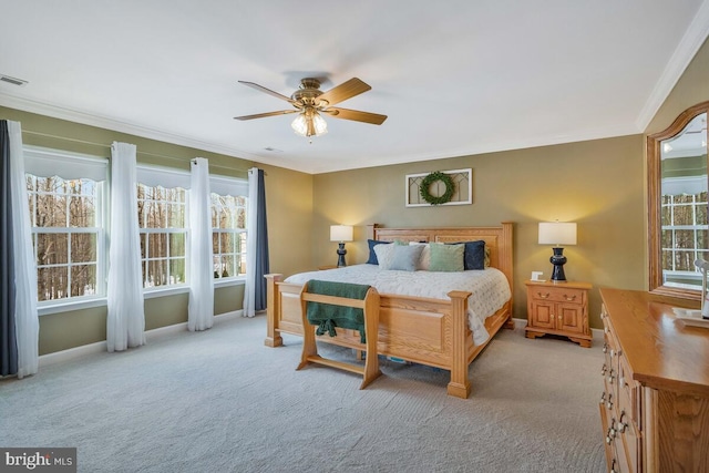 carpeted bedroom with ceiling fan and ornamental molding