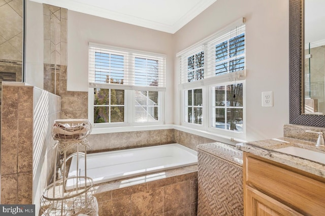 bathroom with crown molding, a relaxing tiled tub, and vanity