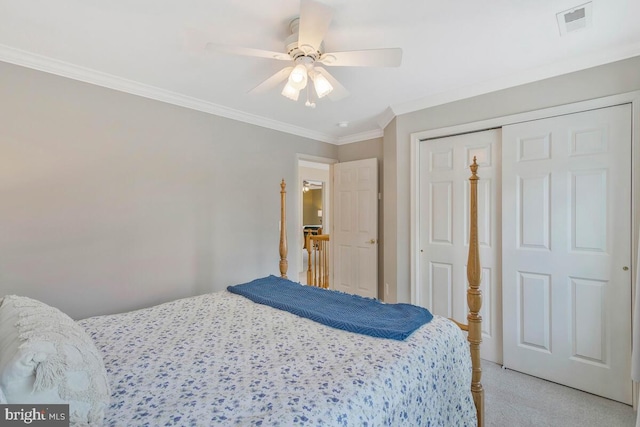 bedroom featuring ornamental molding, light colored carpet, ceiling fan, and a closet