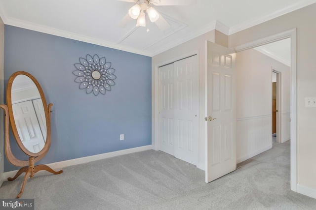 unfurnished bedroom with crown molding, light colored carpet, ceiling fan, and a closet