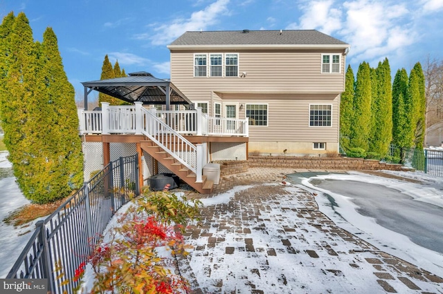 back of property featuring a gazebo and a wooden deck