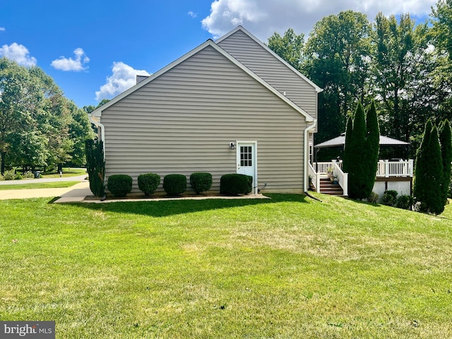 view of side of home featuring a yard and a deck