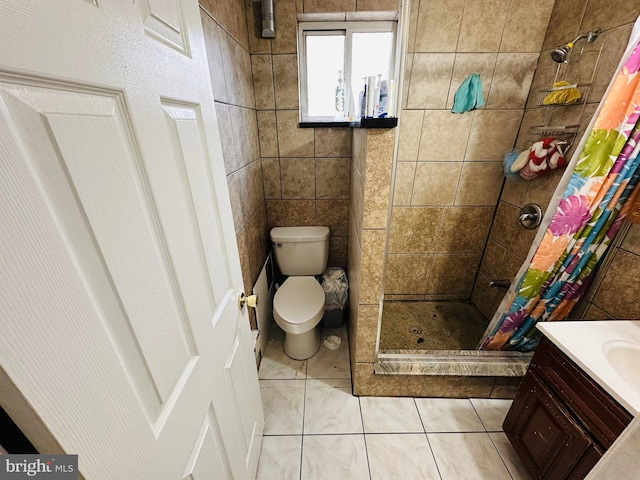 bathroom featuring tile patterned flooring, tile walls, vanity, a shower with curtain, and toilet