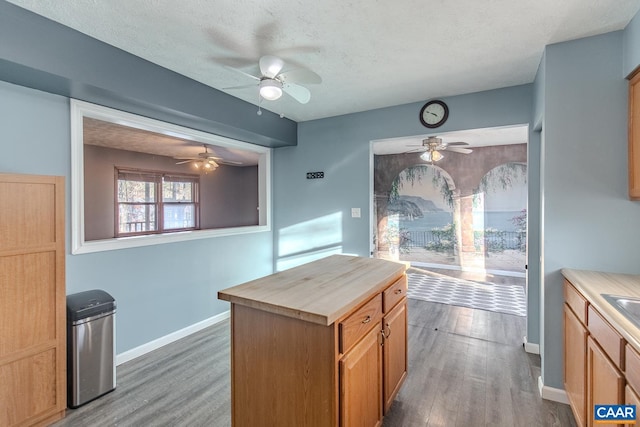 kitchen with wooden counters, dark hardwood / wood-style floors, a center island, and a textured ceiling