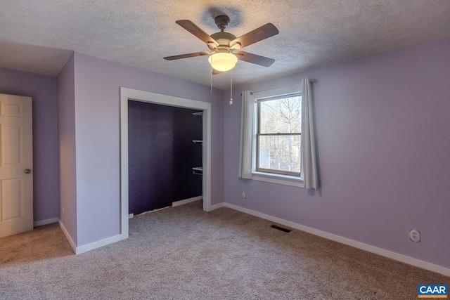 unfurnished bedroom with light carpet, a closet, and a textured ceiling