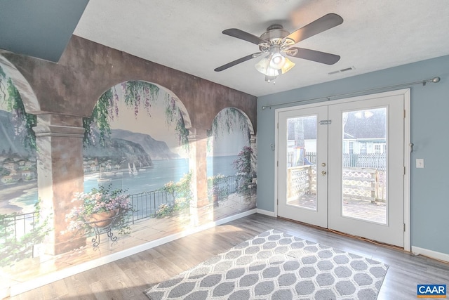 doorway to outside featuring hardwood / wood-style flooring, ceiling fan, and french doors