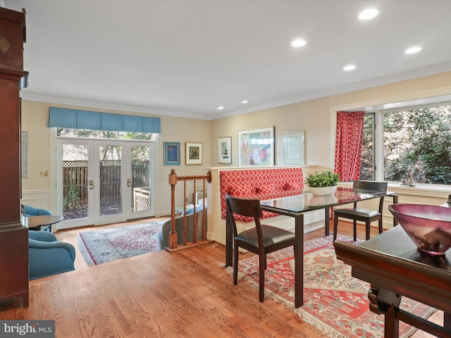 dining area with wood-type flooring, ornamental molding, and french doors