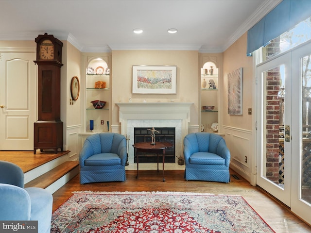 living area featuring crown molding, built in features, and french doors