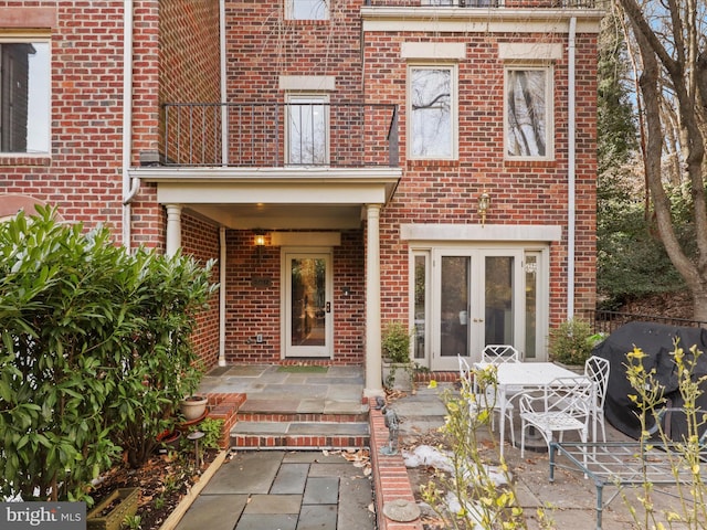 doorway to property featuring a patio, a balcony, and french doors