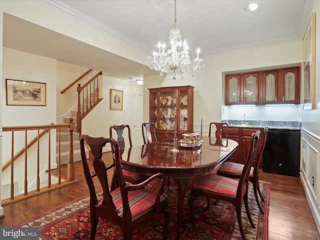 dining room with crown molding, dark wood-type flooring, and a notable chandelier