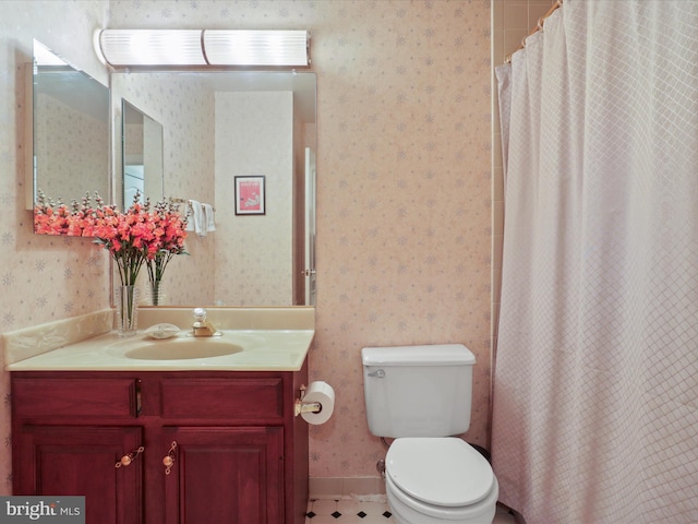 bathroom featuring vanity, toilet, and curtained shower