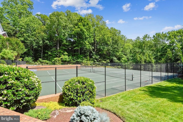 view of tennis court featuring a lawn