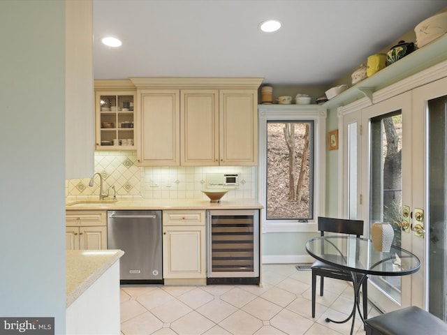 kitchen featuring sink, cream cabinets, decorative backsplash, stainless steel dishwasher, and beverage cooler