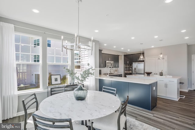 dining space with dark hardwood / wood-style flooring, sink, and a notable chandelier