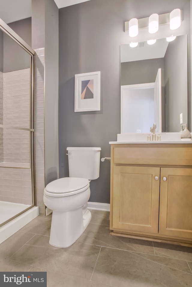 bathroom with an enclosed shower, vanity, tile patterned floors, and toilet