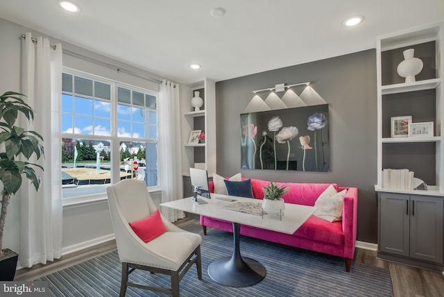 living area featuring dark hardwood / wood-style floors and built in shelves