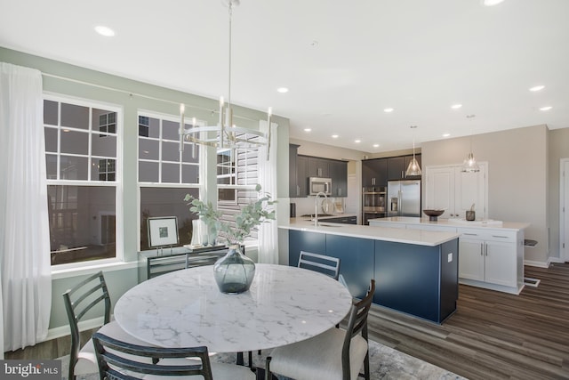 dining space featuring sink, an inviting chandelier, and dark hardwood / wood-style flooring