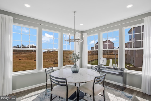 sunroom / solarium featuring an inviting chandelier and a healthy amount of sunlight