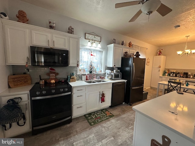 kitchen with sink, tasteful backsplash, black appliances, white cabinets, and decorative light fixtures