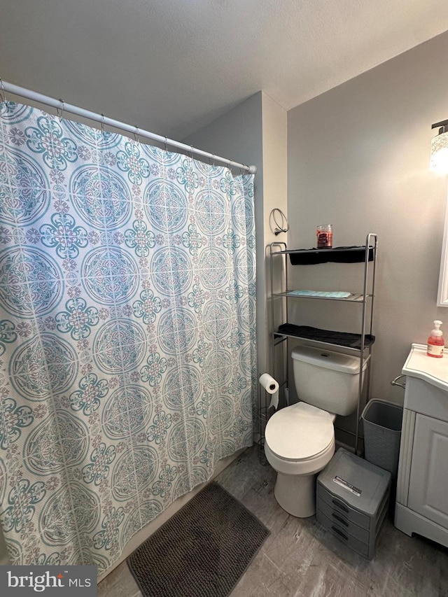 bathroom featuring vanity, hardwood / wood-style floors, and toilet