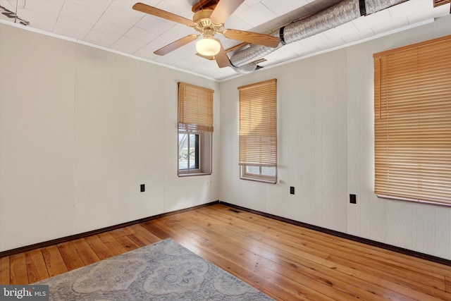 empty room with hardwood / wood-style flooring, crown molding, and ceiling fan