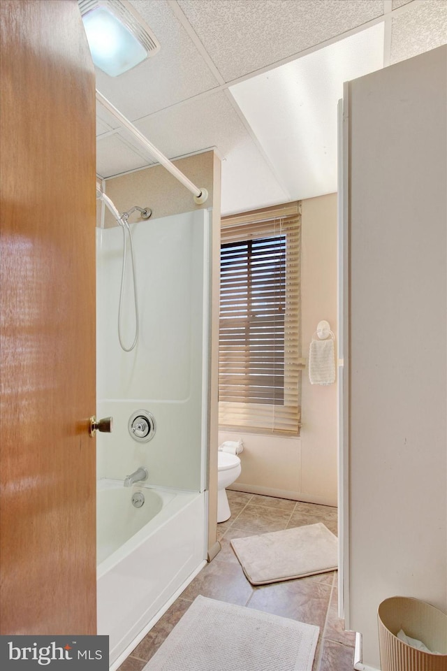 bathroom featuring tile patterned flooring, toilet, and washtub / shower combination