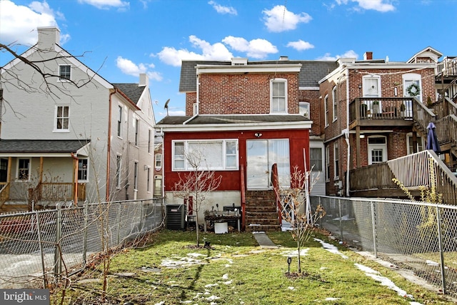 back of property featuring a lawn and central air condition unit