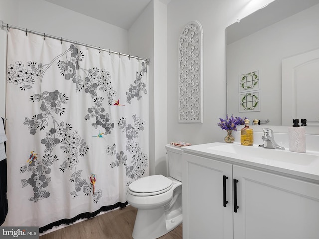 bathroom featuring vanity, hardwood / wood-style flooring, toilet, and walk in shower